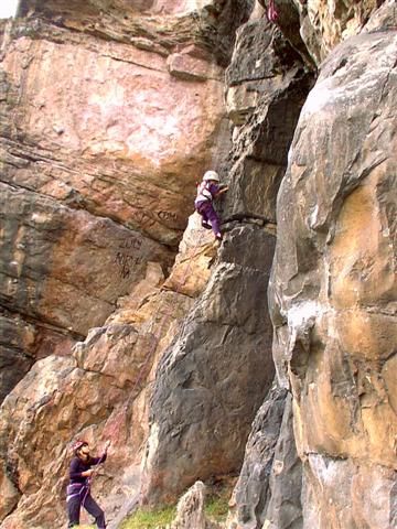 Dos escaladores en la pared naranja