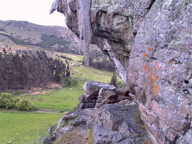 Escalador en un techo de las Rocas con el valle de fondo